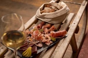 Lokal spekemat og vin servert hos Whitepod Original Hotel i Sveits