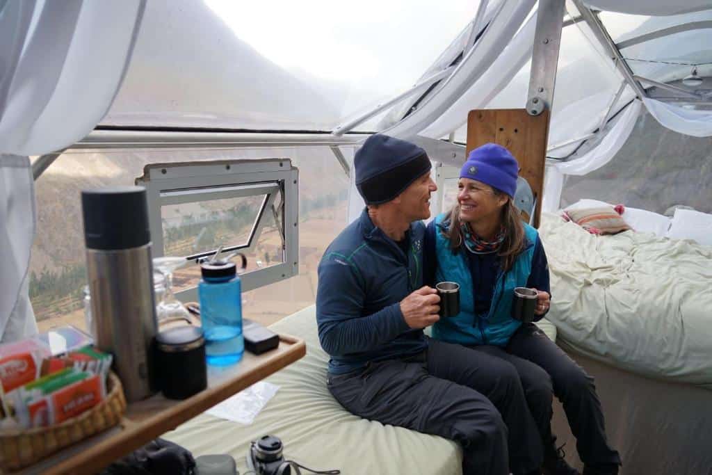 Skylodge Adventure Suites - et par som nyter kaffekopp og spektakulær utsikt på sengen i kapsel 
