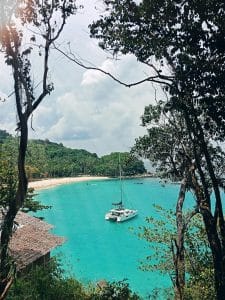 Vakker utsikt mellom palmer til øy i Karibien, luksusferie ombord i flytende boutiquehotell