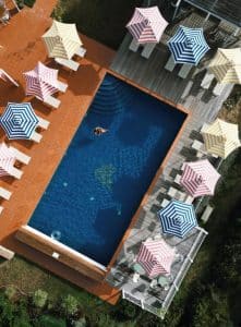 Bassengområde på eksklusiv agriturismo i Toscana sett ovenfra, med solsenger og parasoller – avslappet luksus i rolige, landlige omgivelser.