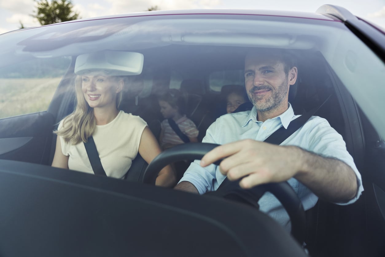 Familie på sommerferie som kjører luksusbil på roadtrip langs kysten.