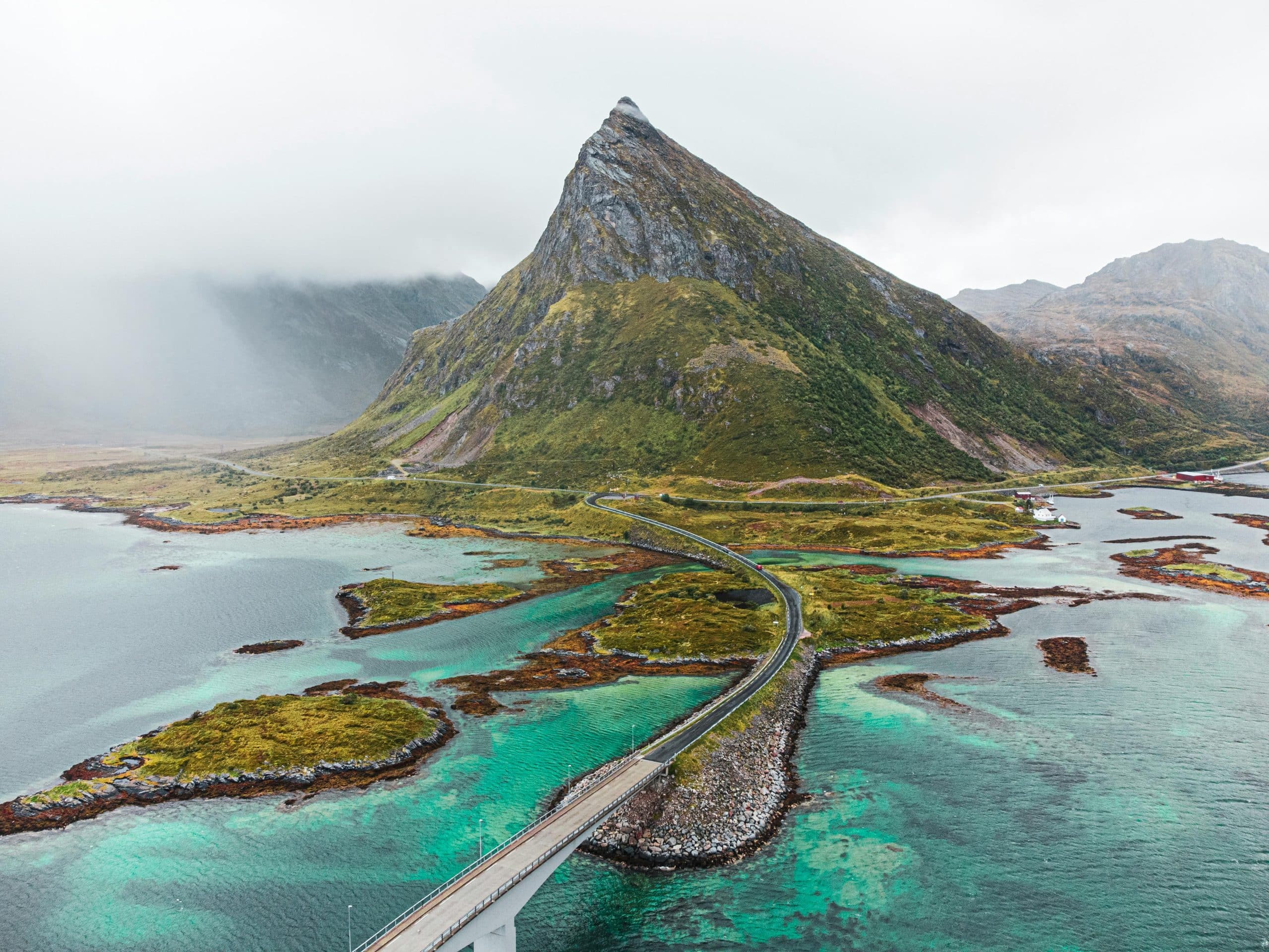 Fjell og kystvei i Lofoten med turkis hav og dramatisk norsk landskap