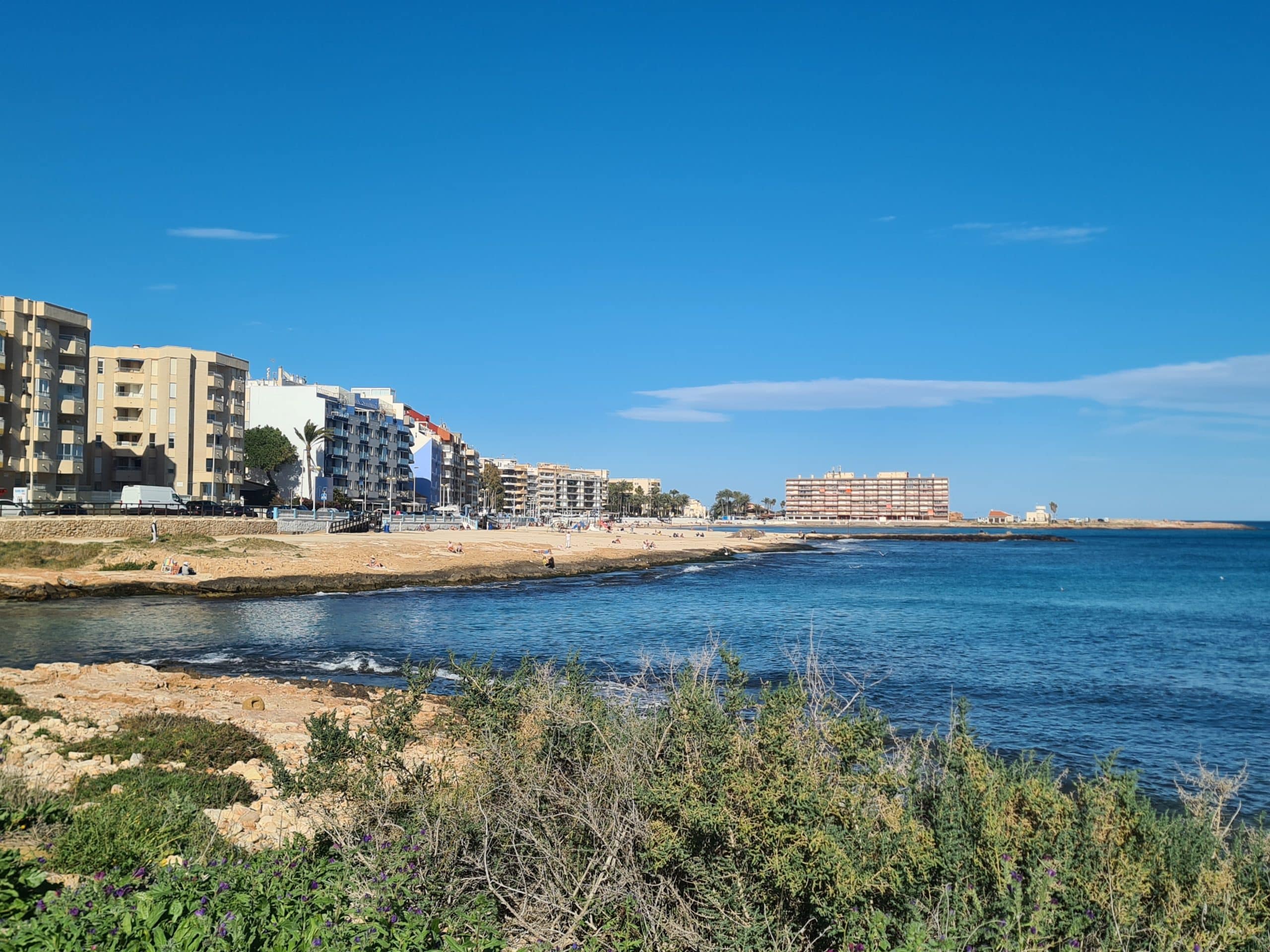 Kystlinjen i Torrevieja med strandpromenade, sandstrand og Middelhavet – populær ferieby på Costa Blanca i Spania.