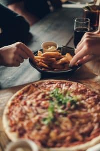 Stemningsbilde av pizza og hygge i restaurant på Spidsbergseter Resort Rondane