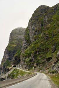 Svingete fjellvei i Norge med tunnel gjennom bratte fjell – spektakulær kjørerute i norsk fjord- og fjellandskap.